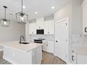 Modern kitchen with white cabinets, quartz countertops, and island at 507 Sun Chaser Dr, Nokomis, FL 34275