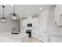 Modern kitchen with white cabinets, quartz countertops, and black appliances at 522 Sun Chaser Dr, Nokomis, FL 34275