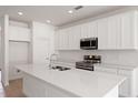Bright kitchen featuring stainless steel appliances and a spacious island with a sink at 9589 Vibrant Lane, Venice, FL 34292