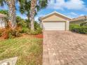 House exterior featuring a two-car garage and a brick paved driveway at 5902 Guarino Dr, Sarasota, FL 34238