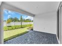 Covered patio with brick pavers and a view of the manicured lawn and landscaping at 9577 Vibrant Lane, Venice, FL 34292