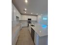 Open concept kitchen with white cabinets, stainless appliances, and a large island with sink at 9577 Vibrant Lane, Venice, FL 34292