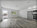 Bright living room with wood-look floors, modern kitchen, and view of the front entrance at 525 Manatee Ct # 14, Venice, FL 34285