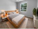 Bright bedroom featuring a large window and a comfortable wooden bed at 33083 Windelstraw Dr, Wesley Chapel, FL 33545