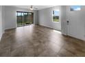 Bright, open living space with tile flooring, featuring sliding glass doors that provide natural light and backyard views at 33083 Windelstraw Dr, Wesley Chapel, FL 33545