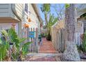 Brick pathway leads to a private backyard with tropical plants at 117 88Th Ave, Treasure Island, FL 33706