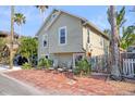 Two-story house with brick walkway, tropical landscaping, and a wood fence at 117 88Th Ave, Treasure Island, FL 33706
