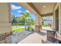 Inviting front porch with seating area, overlooking a landscaped yard and quiet street at 8235 Bird Whistle Ln, Land O Lakes, FL 34637