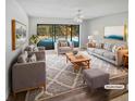 Beautifully staged living room with neutral tones, stylish furniture, and a view of the sparkling pool through sliding glass doors at 3184 Wessex Way, Clearwater, FL 33761