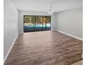 Bright and spacious living room with sleek flooring and sliding glass doors leading to the pool area, perfect for indoor-outdoor living at 3184 Wessex Way, Clearwater, FL 33761