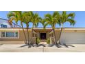 House exterior featuring a two-car garage and lush landscaping at 2504 Hibiscus W Dr, Belleair Beach, FL 33786