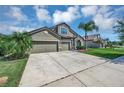 Two story house with three car garage and landscaping at 6722 Wild Elm Ct, Wesley Chapel, FL 33545