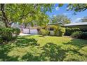 The property features a well-maintained lawn, an attached garage, and mature trees adding to its appeal at 3240 San Mateo St, Clearwater, FL 33759