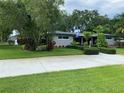 Beautifully landscaped front yard with lush green grass and mature trees surrounding the charming single-story home at 3240 San Mateo St, Clearwater, FL 33759