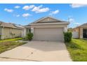 Tan one-story house with a two-car garage and grey front door at 12120 Barnsley Reserve Pl, Gibsonton, FL 33534