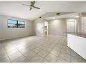 Bright living room with high ceilings, a ceiling fan, and tiled flooring throughout at 9308 San Bernandino Ave, Englewood, FL 34224