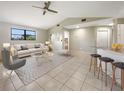 Bright living room with high ceilings, a ceiling fan, and tiled flooring throughout at 9308 San Bernandino Ave, Englewood, FL 34224