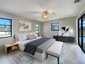 Well-lit main bedroom featuring tile flooring, large windows, and a ceiling fan at 9308 San Bernandino Ave, Englewood, FL 34224