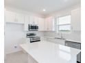 Bright kitchen featuring white cabinets and a large quartz island at 17339 Peregrine Way, Punta Gorda, FL 33982