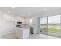 Modern kitchen with white cabinets, island, and sliding glass doors at 17339 Peregrine Way, Punta Gorda, FL 33982