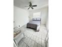 Cozy bedroom with a queen-sized bed, tiled floors, and a ceiling fan at 1433 S Belcher Rd # C1, Clearwater, FL 33764