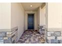 Front entry with dark door and stone accents at 9034 Sandy Bluffs Cir, Parrish, FL 34219