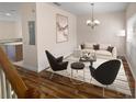 Living room featuring hardwood floors, a beige sofa, and two black armchairs at 8882 Christie Dr, Largo, FL 33771