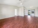 Spacious living room featuring hardwood floors and ample natural light, flowing seamlessly into the kitchen area at 7087 Spinnaker Blvd, Englewood, FL 34224