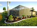 Landscaped backyard oasis with lush plants and a screened enclosure at 4202 Perch Cir, Port Charlotte, FL 33948