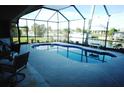 Relaxing pool and patio area with screened enclosure and water view at 4202 Perch Cir, Port Charlotte, FL 33948