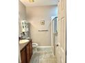 Bathroom with tiled floor, shower, and wood cabinets at 17274 Asmara Ct, Punta Gorda, FL 33955
