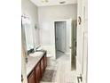 Bathroom with tiled floor, shower, and vanity with wood cabinets at 17274 Asmara Ct, Punta Gorda, FL 33955