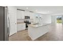 Open kitchen featuring stainless appliances, granite countertops, white cabinets and a center island with a sink at 145 Lazy Shore Dr, Nokomis, FL 34275
