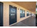Exterior view of condo unit's entrance and walkway with surrounding vegetation at 6400 46Th N Ave # 102, Kenneth City, FL 33709