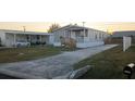 Single-story home with a driveway, carport, and well-maintained lawn at 1386 Ibis Dr, Englewood, FL 34224