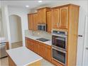 Modern kitchen featuring stainless steel appliances, double ovens, and custom wooden cabinetry at 2302 123Rd E Pl, Parrish, FL 34219