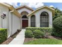 House entrance with arched windows and landscaped walkway at 533 Bent Oak Ct, Spring Hill, FL 34609