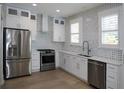 Bright kitchen with stainless appliances, white cabinetry, stylish backsplash, and hardwood flooring at 236 20Th Ave Se, St Petersburg, FL 33705