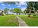 Concrete pathway meanders through grassy area with lush landscaping and water views at 6219 Palma Del Mar S Blvd # 301, St Petersburg, FL 33715