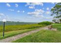 Pathway along waterfront with bench, grass, and trees offering scenic views at 6219 Palma Del Mar S Blvd # 301, St Petersburg, FL 33715