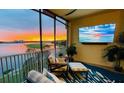 Relaxing balcony featuring comfortable seating, beautiful sunset views, and a flat-screen television for entertainment at 6450 Watercrest Way # 402, Lakewood Ranch, FL 34202