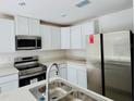 Modern kitchen featuring stainless steel appliances and white cabinetry at 18313 Garman Ave, Port Charlotte, FL 33948