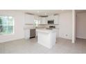 Well-lit kitchen with modern fixtures, stainless appliances, and island at 18059 Regan Ave, Port Charlotte, FL 33948