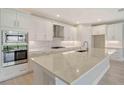 Contemporary kitchen featuring a large island, white cabinets, and stainless steel appliances at 4910 Carova Way, Lakewood Ranch, FL 34211