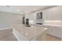 Modern kitchen features a large island, stainless steel appliances, and sleek white cabinetry at 4910 Carova Way, Lakewood Ranch, FL 34211