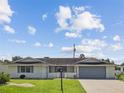 Ranch-style home with attached garage and well-manicured lawn at 716 Fox Hills Dr, Sun City Center, FL 33573