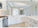Open concept kitchen with white cabinets and large island at 18324 Rockport Pl, Lakewood Ranch, FL 34211