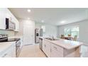 Modern kitchen with white cabinets, island, and stainless steel appliances at 108 Castile Ct, Punta Gorda, FL 33983