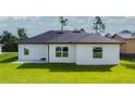 Rear view of house with large windows and patio at 2165 Music Ln, North Port, FL 34286