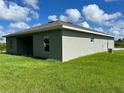 Side view of a new light grey house with green grass at 12577 Willmington Blvd, Port Charlotte, FL 33981